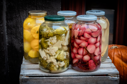 sárga, zöld és bordó fermentált zöldségek befőttesüvegekben